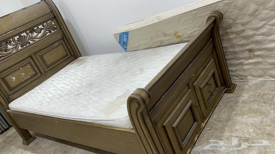 A strong used new wooden bed with two mattresses and a small closet63296546757634111