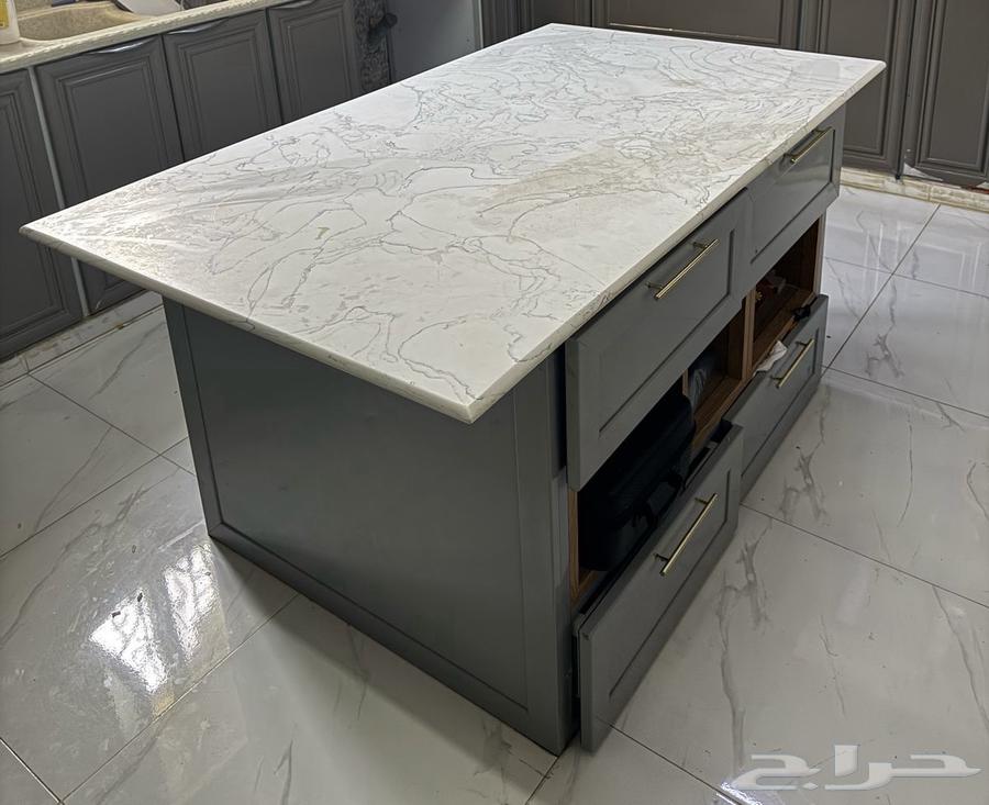 A kitchen island with a side of shelves and four drawers, and on the other side three cabinets.63204510741761112