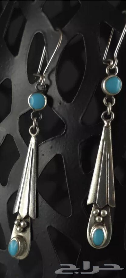 Long silver earrings stamped and inlaid with turquoise stone.63201394504449113