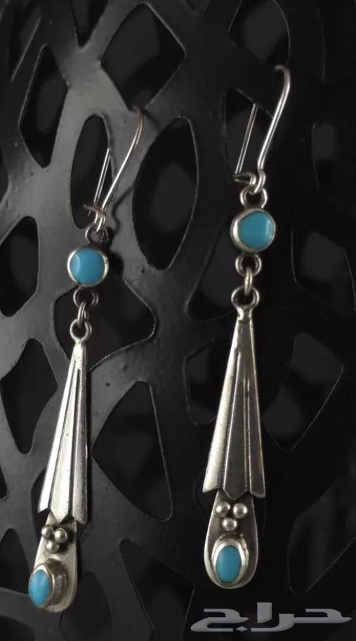 Long silver earrings stamped and inlaid with turquoise stone.63201394504449114
