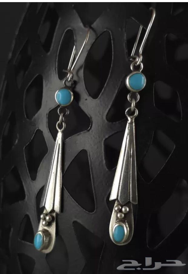 Long silver earrings stamped and inlaid with turquoise stone.63201394504449112