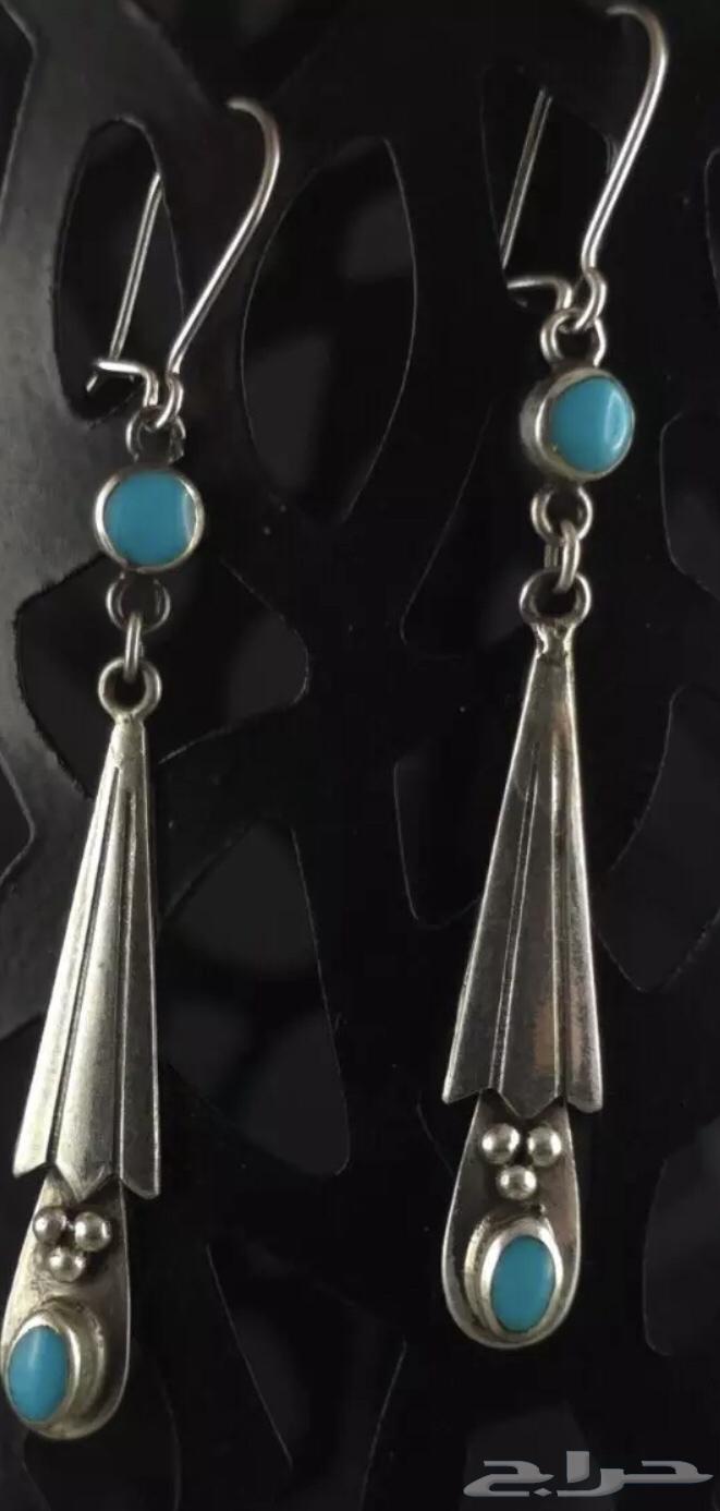 Long silver earrings stamped and inlaid with turquoise stone.63201394504449111