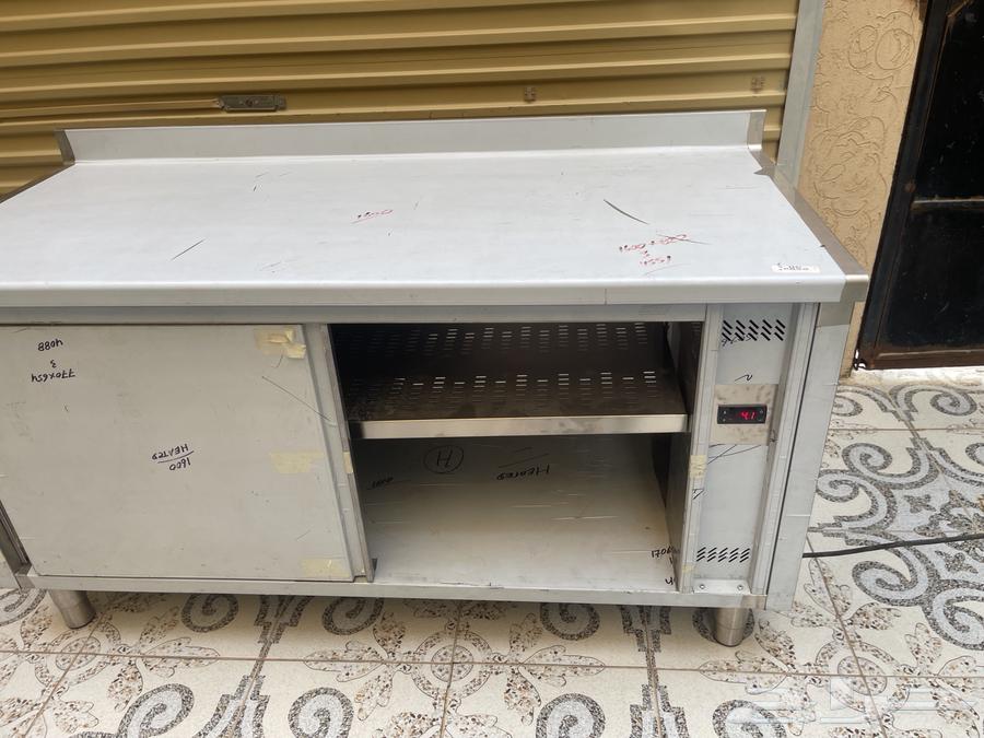 A stainless steel table with integrated preparation space and storage below, heater for warming63059237315203114