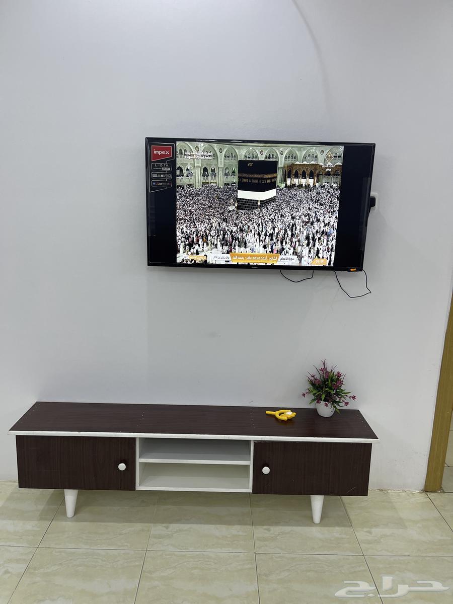 A sofa with cushions, tables, and a 35-inch television.63414812515713111