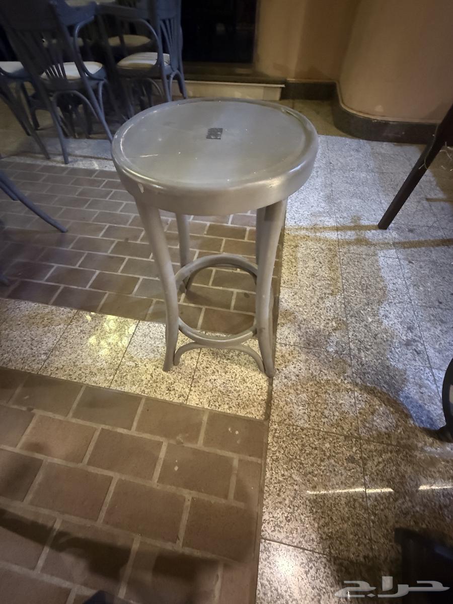 Chairs, tables, and a cart for sale at a cafe63704836020610113