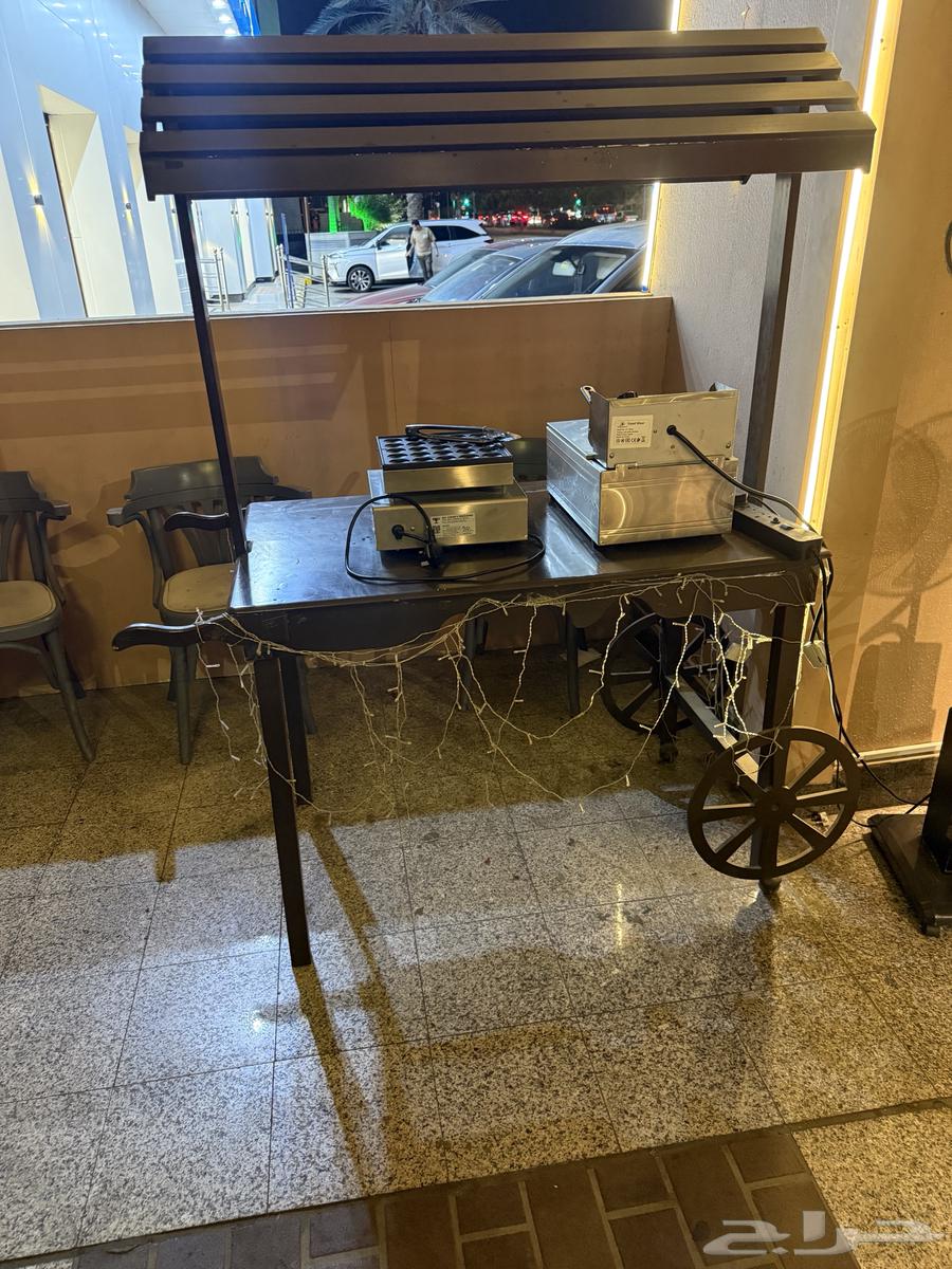Chairs, tables, and a cart for sale at a cafe63704836020610112