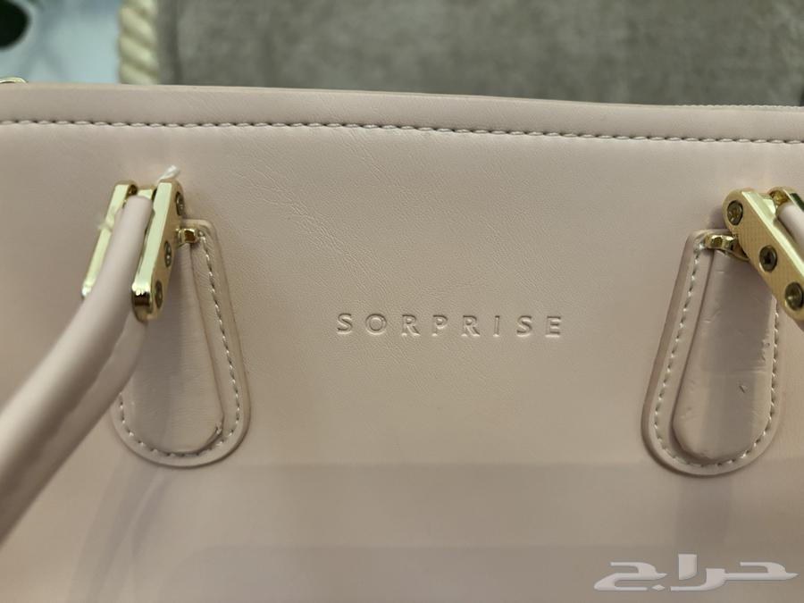شنطة ماركة surprise نسائية بحالة ممتازة ومعها هدية64429451834753111