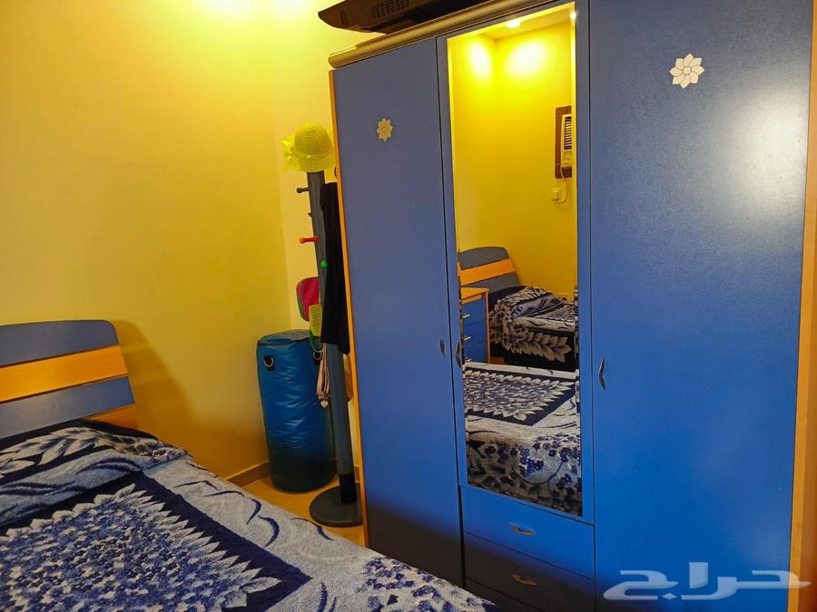 A bedroom with two beds, a large wardrobe, and two desks64538869531395110