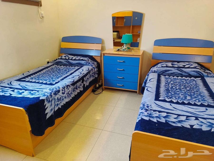 A bedroom with two beds, a large wardrobe, and two desks64538869531395112
